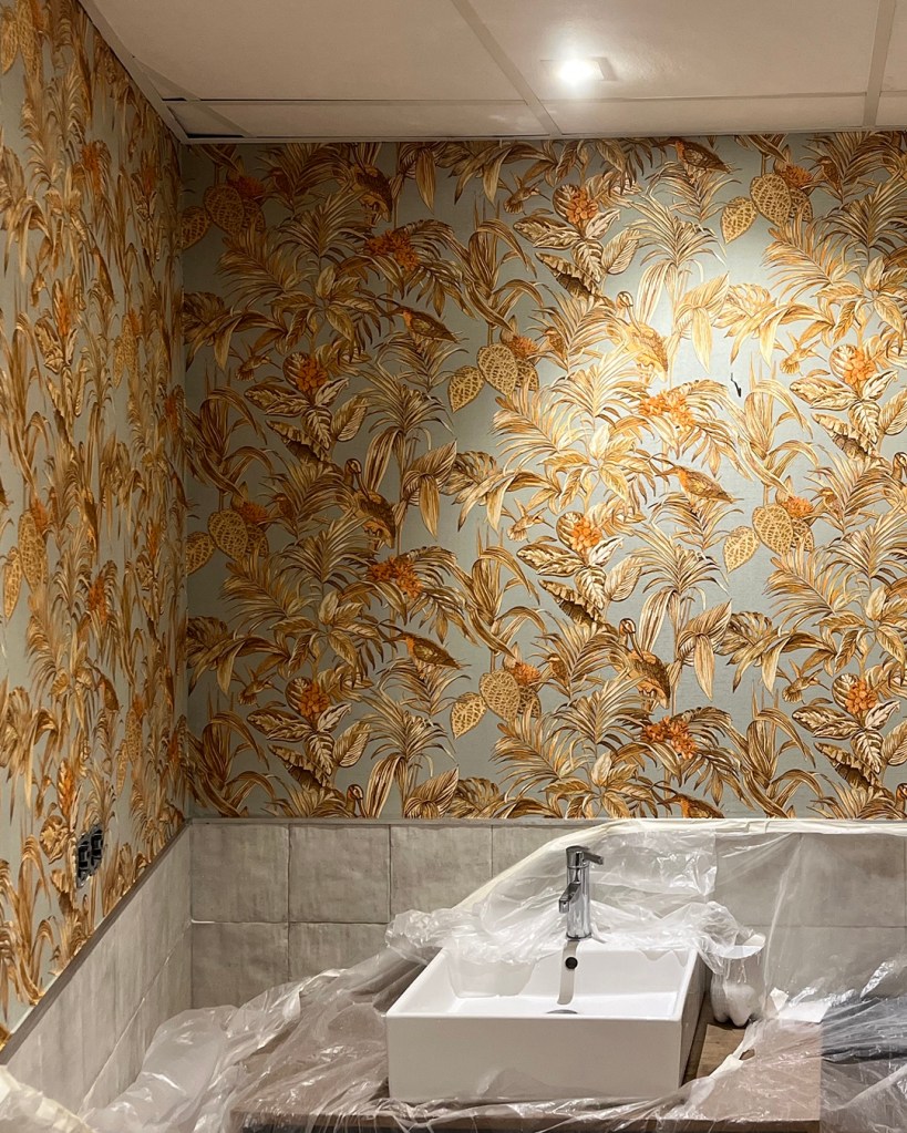 Baño de restaurante decorado con papel pintado vinílico por Empapelador Madrid